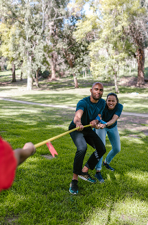 Deux participants concentrés tirent sur une corde pendant un jeu d’équipe en extérieur, illustrant l’effort, la coordination et l’esprit de compétition.